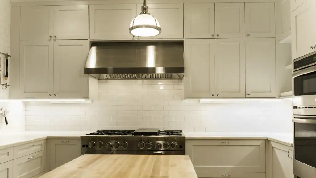 White shaker cabinets with stacked uppers and commercial hood