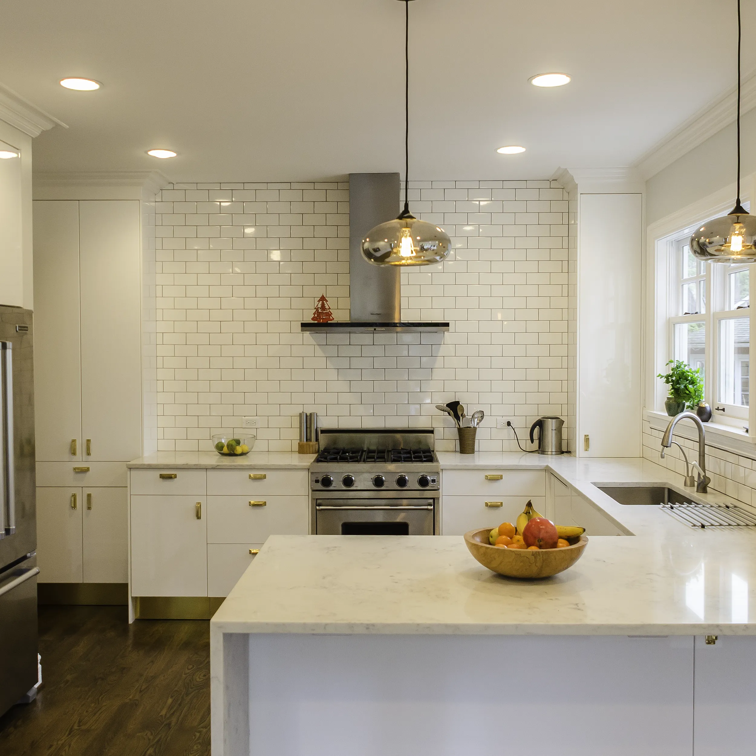 High-gloss white IKEA kitchen cabinets with brass hardware in a Seattle kitchen
