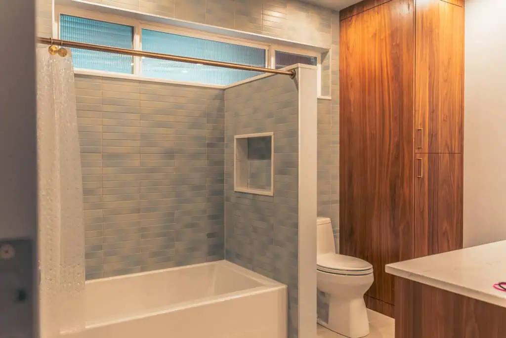 Tile detail extending past shower to toilet wall