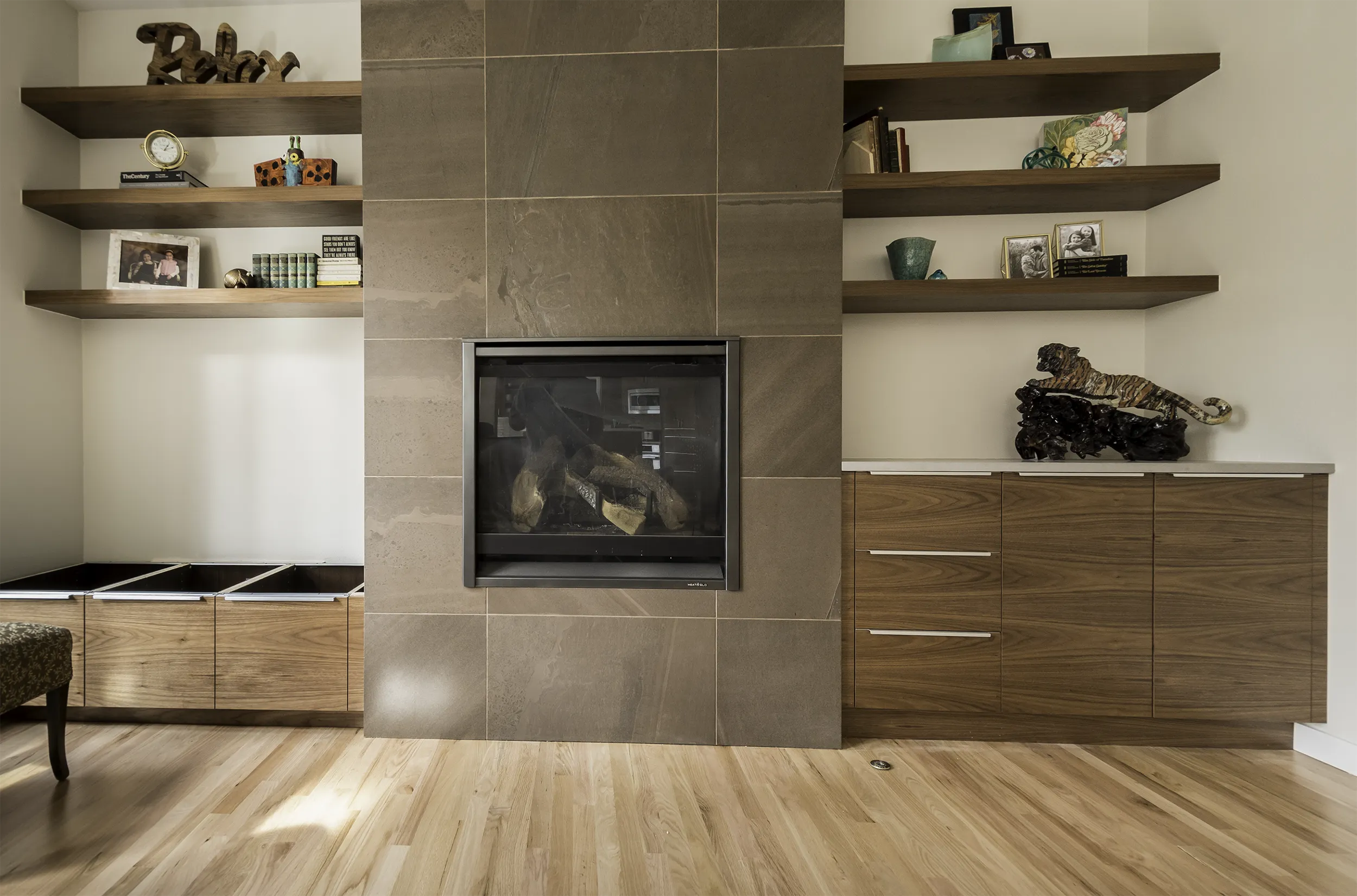 Sammamish living room fireplace with teak built-ins, floating walnut shelves, and large-format porcelain tile surround