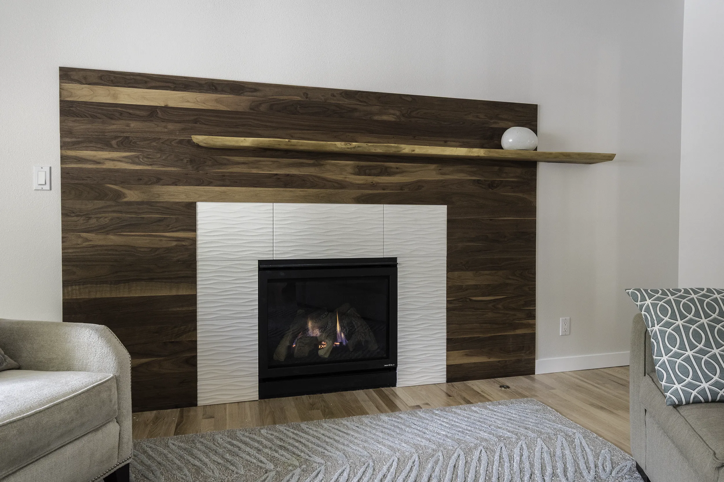 Sammamish den fireplace with walnut plank wall and offset live-edge mantel
