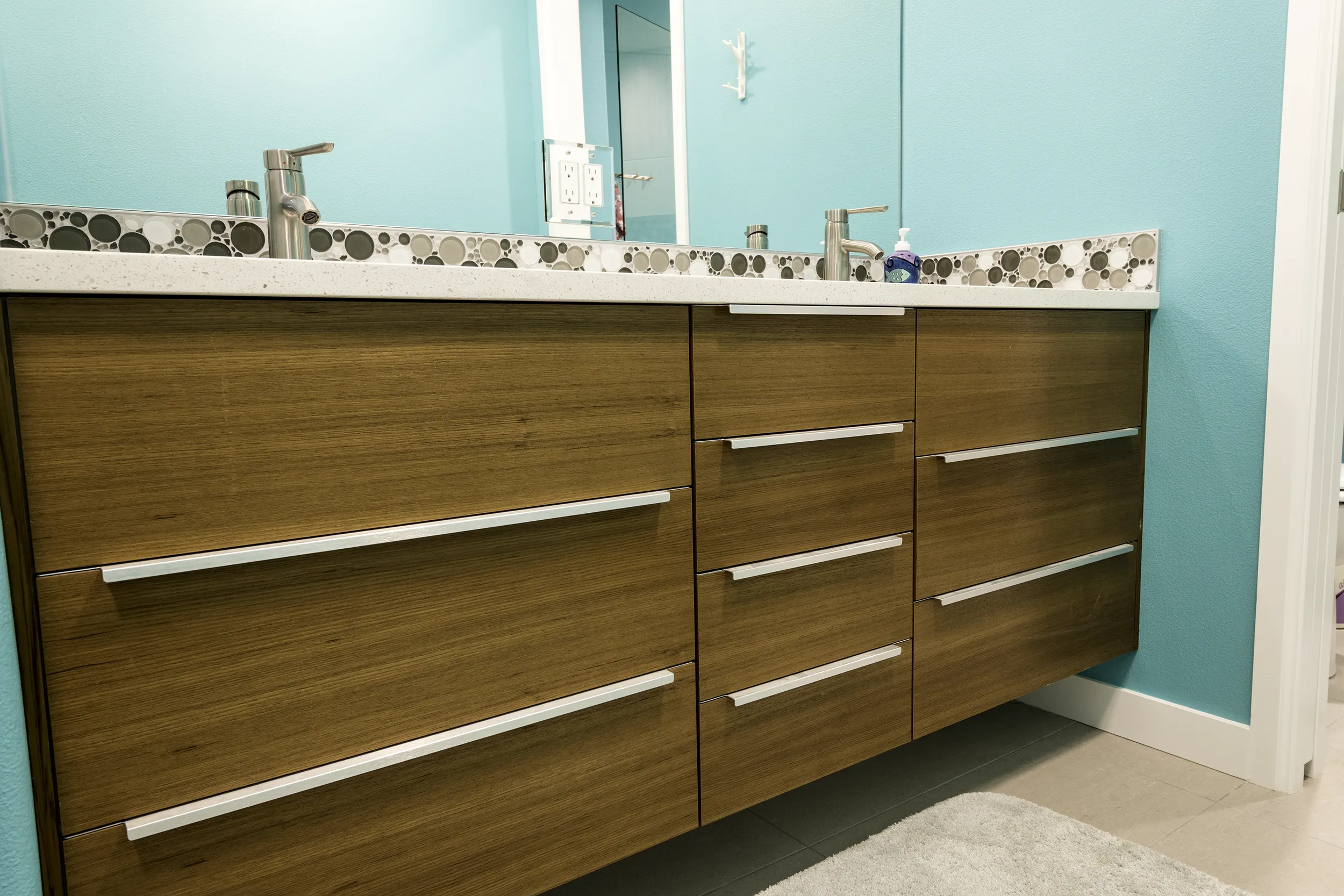 Kids bathroom floating double vanity with custom teak faces and bubble mosaic backsplash