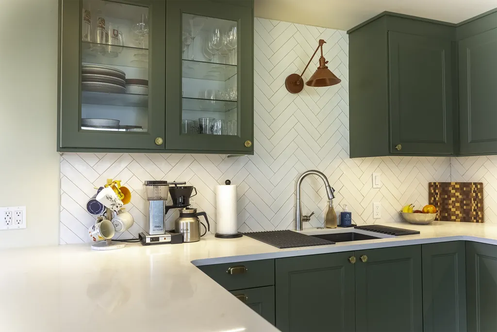 West Seattle kitchen remodel detail with white herringbone tile, brass pulls, and a copper sconce