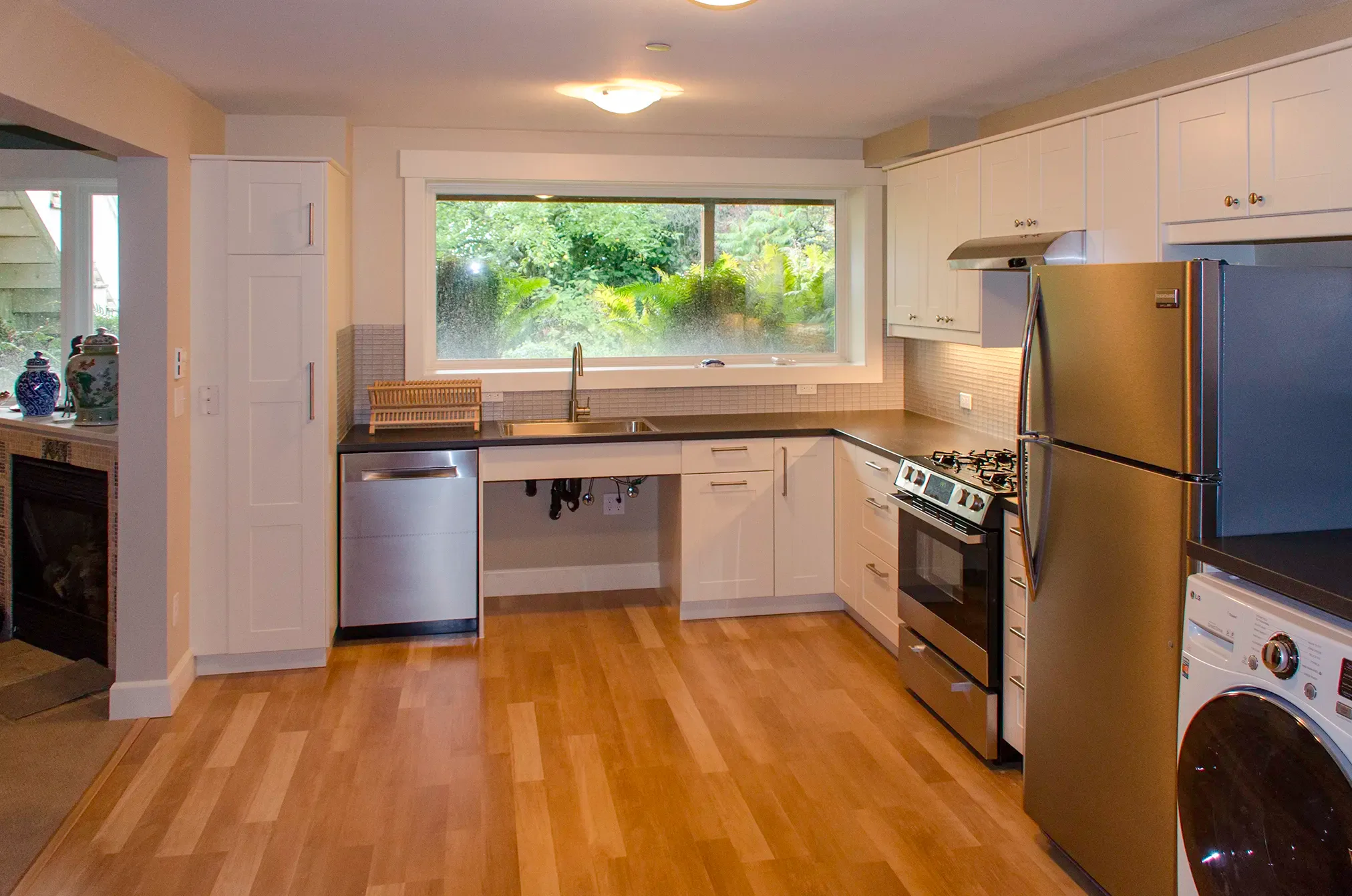 Mercer Island basement apartment kitchen with white shaker cabinets and a gas range