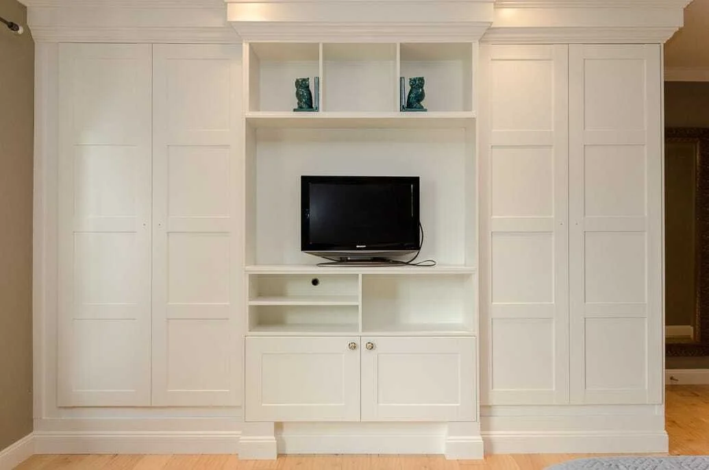 Custom wardrobe and display shelving built with IKEA cabinetry