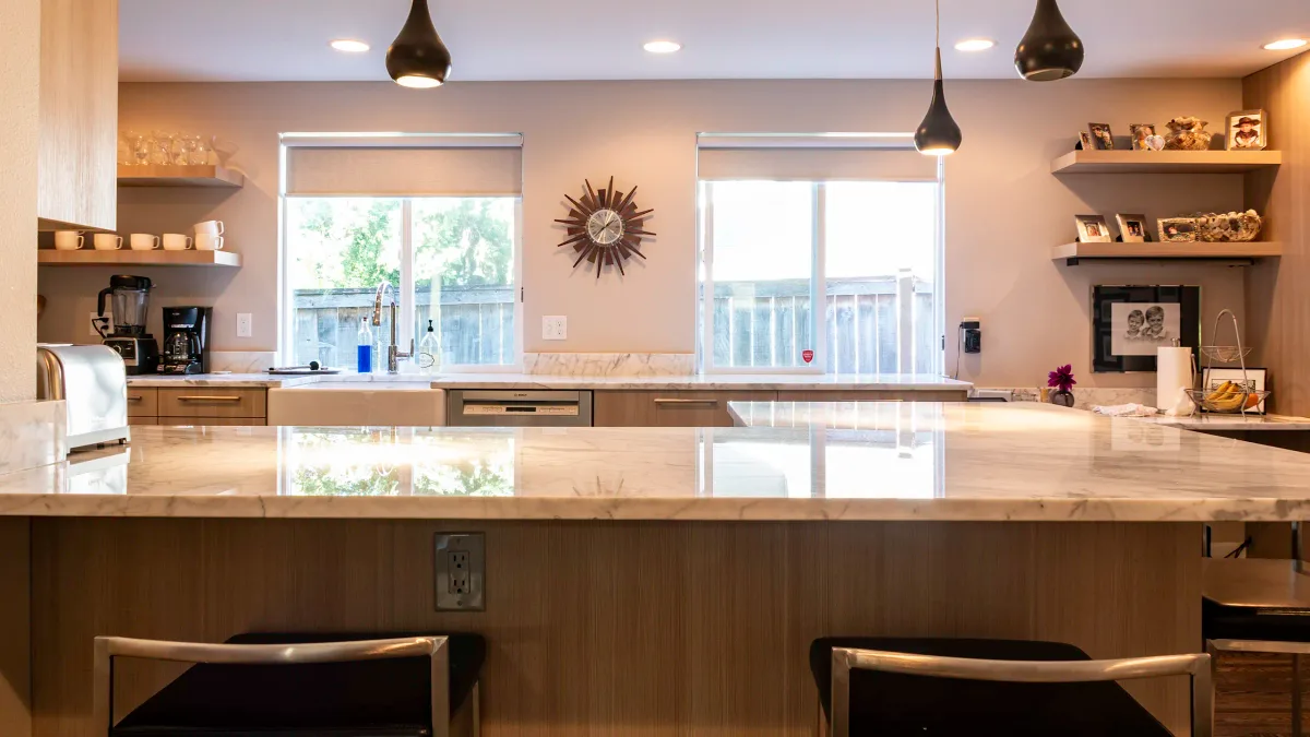 Polished stone island countertop in Bellevue kitchen remodel with pendant lighting