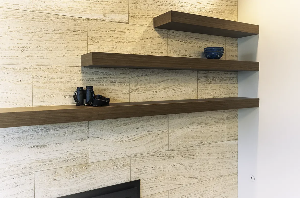 Custom walnut floating shelves over fireplace